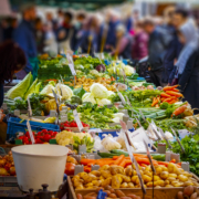 Colorful sales stand with vegetables at the farmers market in Mainz with many people